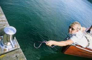 Woman on boat reaching for jetty