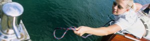 Woman on boat reaching for jetty